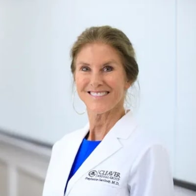 Professional female doctor in white lab coat at Cleaver Medical Group, expert in skincare and anti-aging treatments.